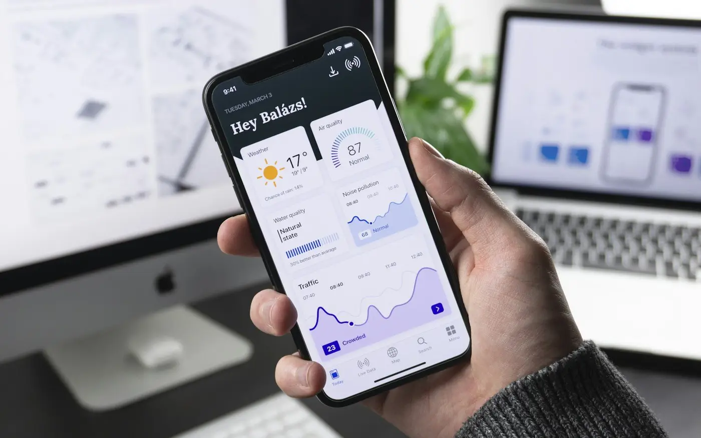 Hand holding a phone with a mobile app open